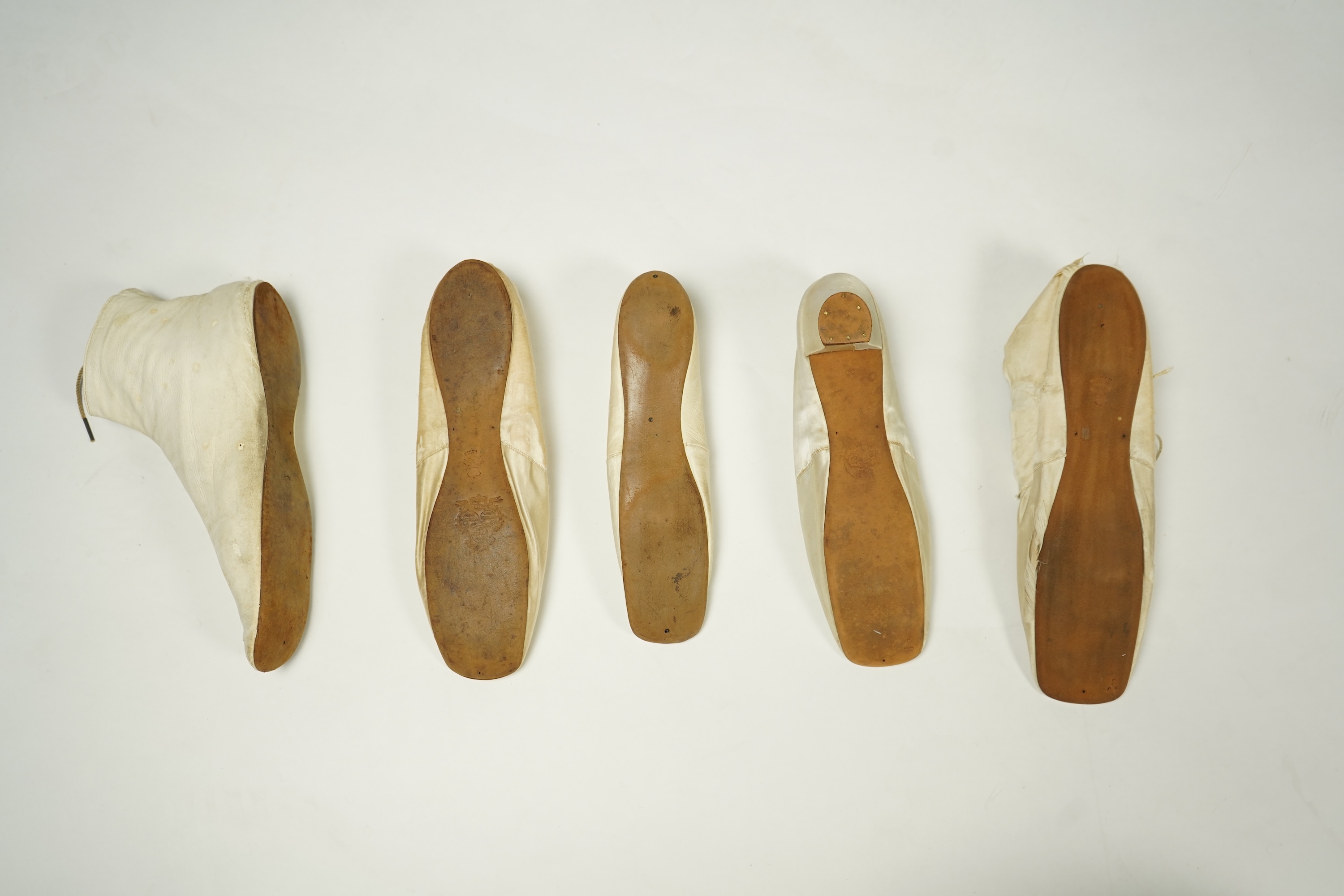 A 19th century hand made cream kid leather ladies ankle boot and four differing cream silk and satin single wedding shoes. All with leather soles. Possibly a traveller's sample range. Boots 24.5cm long (heel to toe). Con